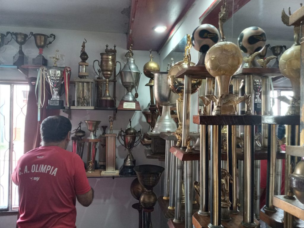 El presidente de Olimpia, Raúl Trabuco, restaurando trofeos de la institución en su sede