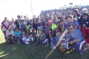 Los juveniles de Lavalleja posan en el campo de juego del Dickinson tras ganar el Interior y recibir la Copa