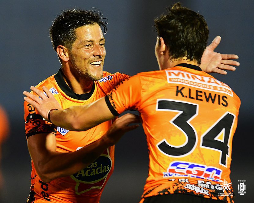 Pablo Olivera acaba de convertir el gol del triunfo y es saludado por Kevin Lewis (foto AUF)