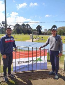 Mauro Costa y Santiago Rodríguez, junto a la bandera del departamento, en la Pista Darwin Piñeyrúa